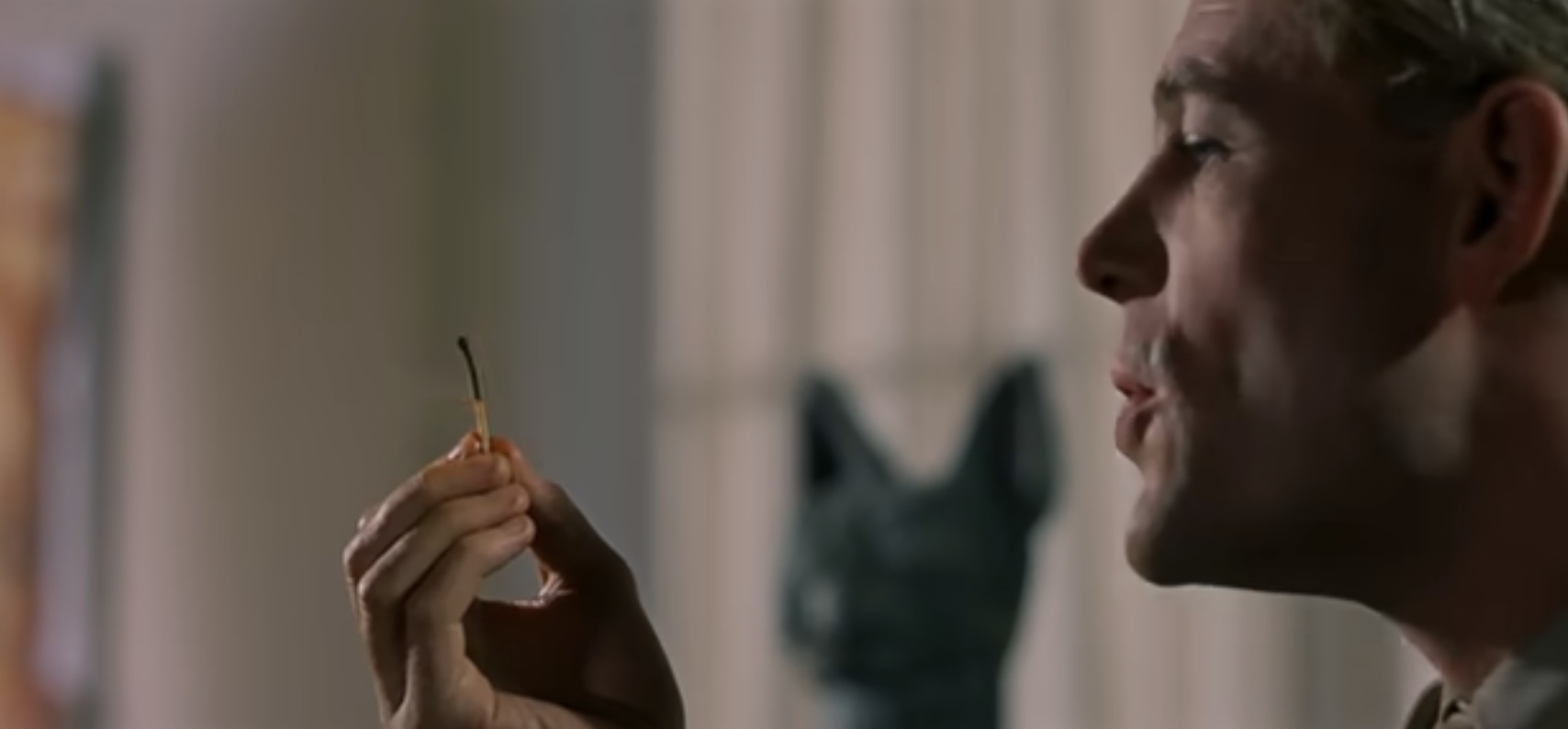 Film still of a man holding a match
